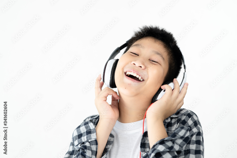 Fat Asian preteen boy using headphone on white wall. Fat Asian preteen boy using headphone on white wall.