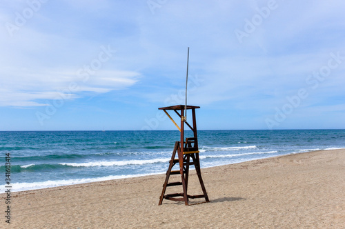 Brown wooden lifeguard stand tower in the empty beach of Marbella during quarantine