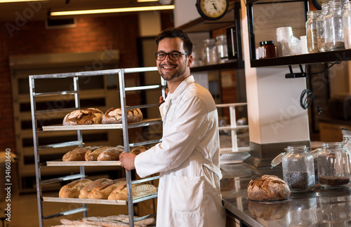 Fotografiet Portrait of young male baker standing at bakery.