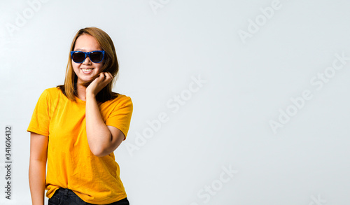 Beautiful young woman with yellow t-shirt and sunglasses feeling funny happy on white background,Summer concept banner background.