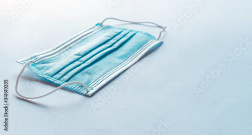 Medical mask isolated and at an angle on a plain background