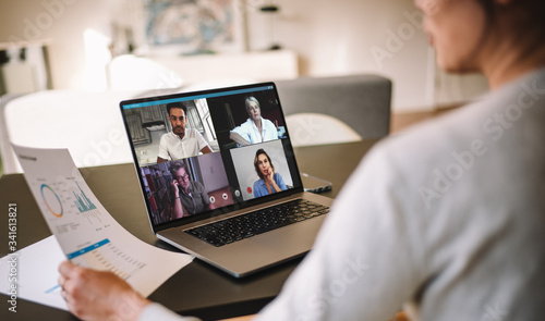 Woman discussing business with team over a video conference photo