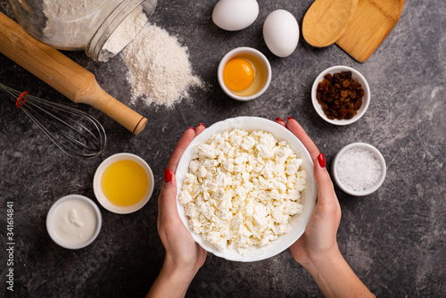 Girl holds a plate with cottage cheese. Farm products. Healthy food. Top view.