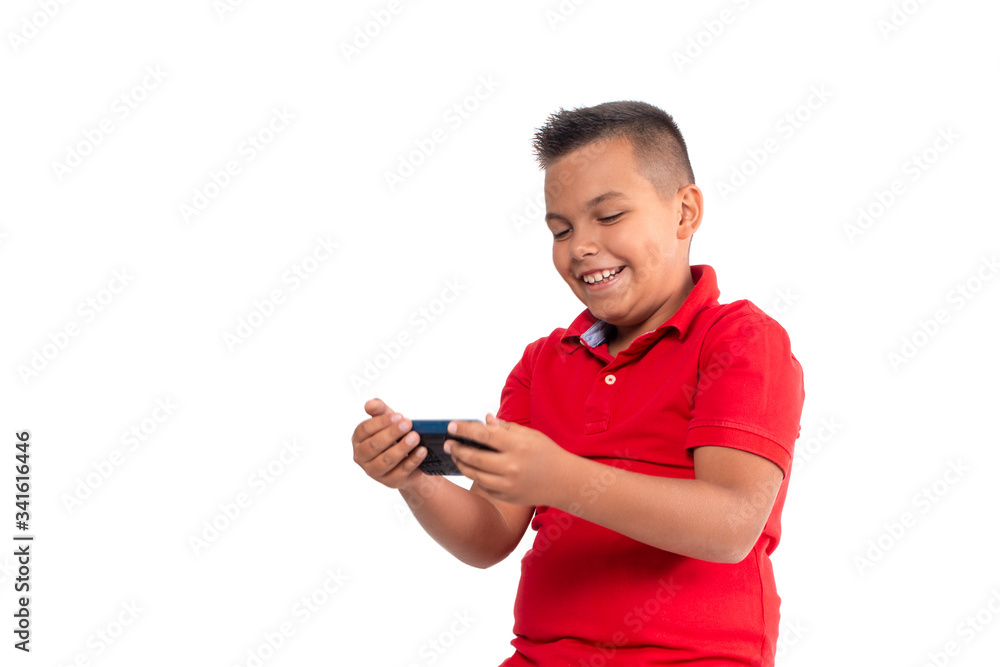 A young smiling boy emotionally playing games or communicates on the Internet on phone. A young smiling boy emotionally playing games or communicates on the Internet on phone.