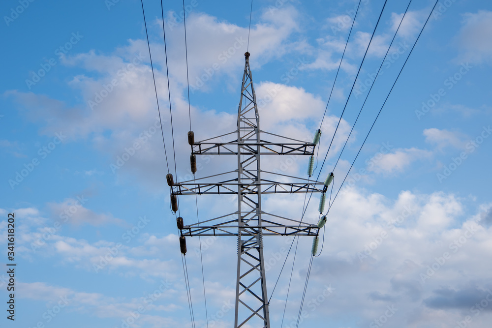 Power pole and lines with transformers and street light, bright blue sky with clouds Power pole and lines with transformers and street light, bright blue sky with clouds