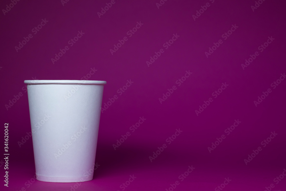An empty white paper cup on a pink background An empty white paper cup on a pink background
