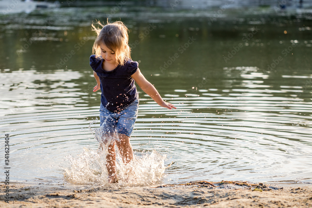 Fototapeta premium Girl jumping through water in summer.