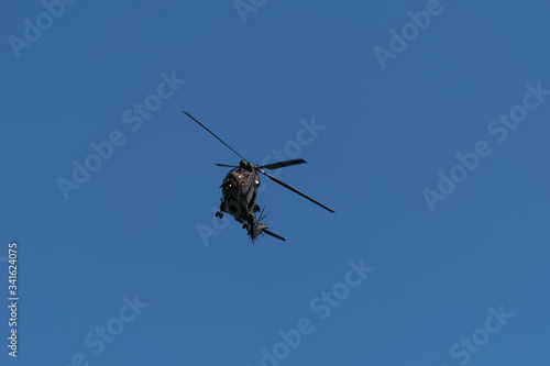 A military helicopter banks towards the camera on a warm spring afternoon during the Coronavirus lockdown in the UK