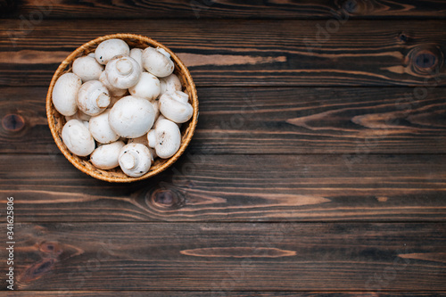 Dark wooden background with champignons. Copy space with mushrooms