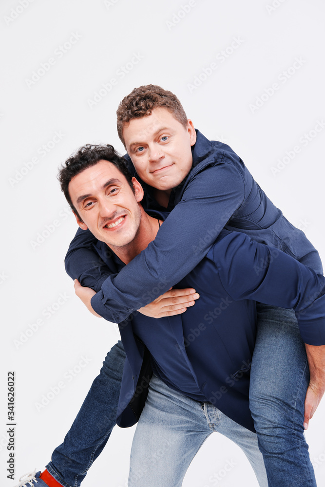One man rolls another on his back. The concept of friendship between men One man rolls another on his back. The concept of friendship between men