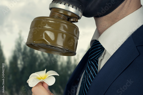 Close up portrait of man in a protective gas mask with flower photo