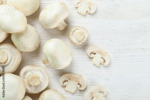 Bunch of farm raised organic mushrooms laid in composition on textured background. Champignons on table counter. Clean eating concept. Background, close up, flat lay, top view.