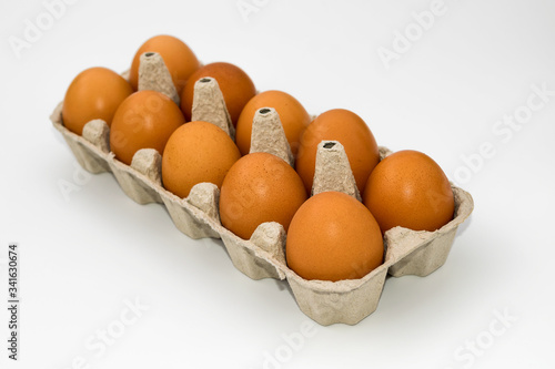 Chicken eggs in cardboard egg box on white background. Raw chicken eggs in open egg box on a white background. Eggs in the package.