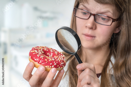 Scientist examines a donut with magnifying glass