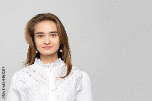 Beautiful young woman portrait. Studio shot, isolated on gray background © simikov