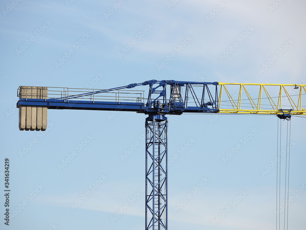 Tower cranes work during the construction of a multi-story building. New apartments for residents and premises for offices. Risky work at height. Lifting heavy building materials. City development Tower cranes work during the construction of a multi-story building. New apartments for residents and premises for offices. Risky work at height. Lifting heavy building materials. City development