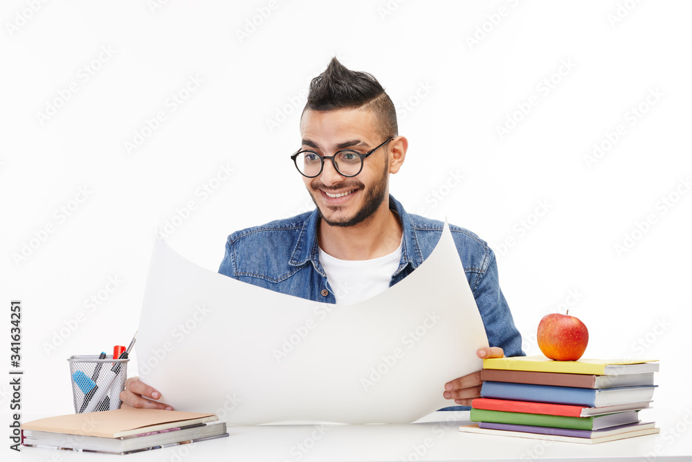 Student holds a big piece of paper in front of him. Student holds a big piece of paper in front of him.