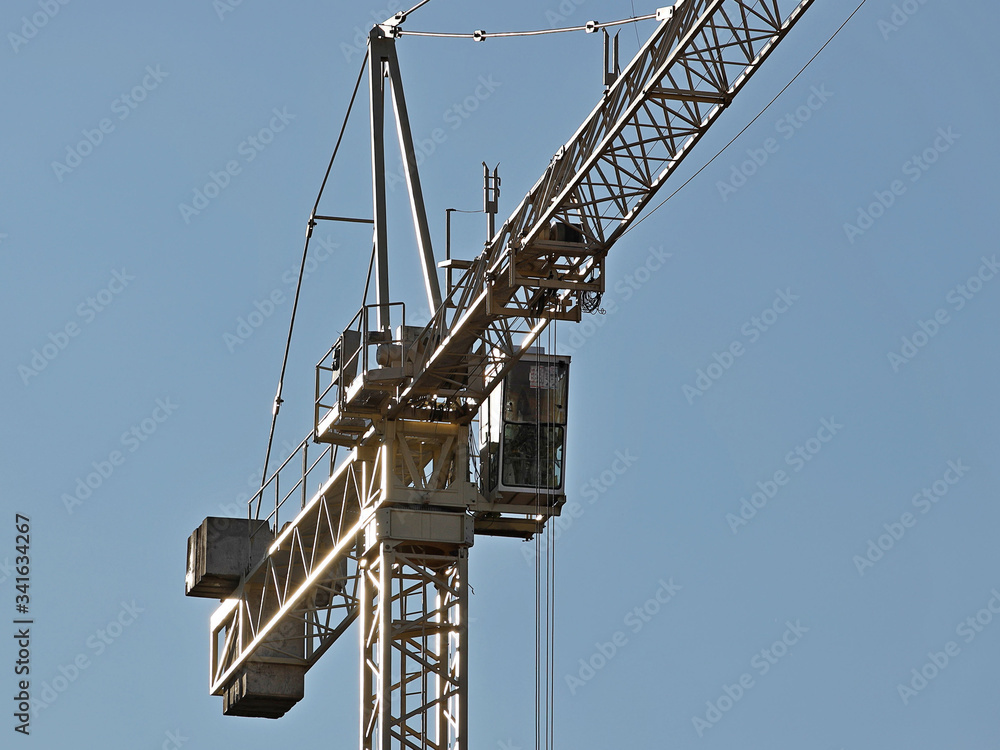Tower cranes work during the construction of a multi-story building. New apartments for residents and premises for offices. Risky work at height. Lifting heavy building materials. City development Tower cranes work during the construction of a multi-story building. New apartments for residents and premises for offices. Risky work at height. Lifting heavy building materials. City development