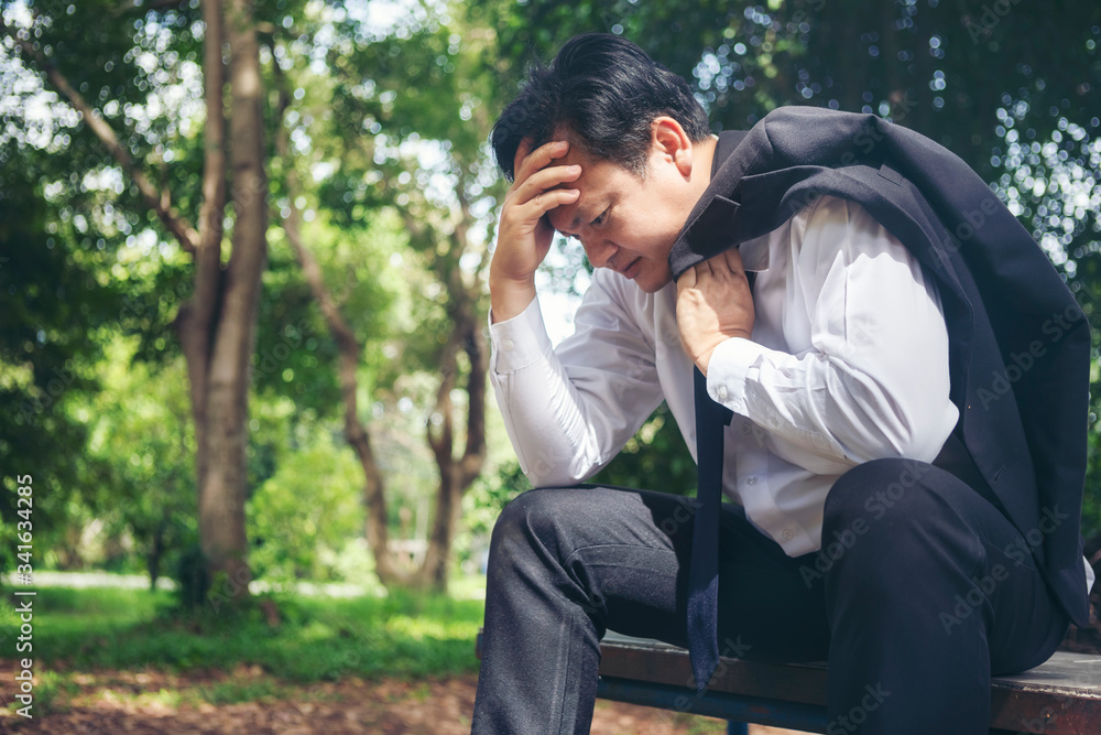 A young man sat on the table in stress after being fired from the sluggish economic conditions after the Covid-19 outbreak. A young man sat on the table in stress after being fired from the sluggish economic conditions after the Covid-19 outbreak.