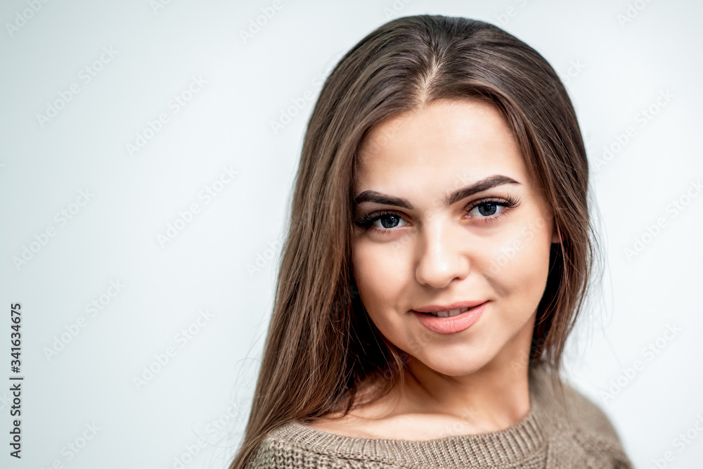 Portrait of beautiful caucasian young woman with perfect hairstyle and makeup on white background.