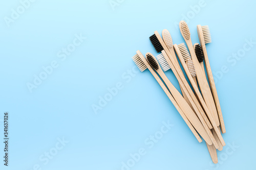 Zero waste and without plastic concept. Set of eco friendly bamboo toothbrushes on light pastel blue surface. Top view, copy space, horizontal orientation. Layout natural organic hygiene products.