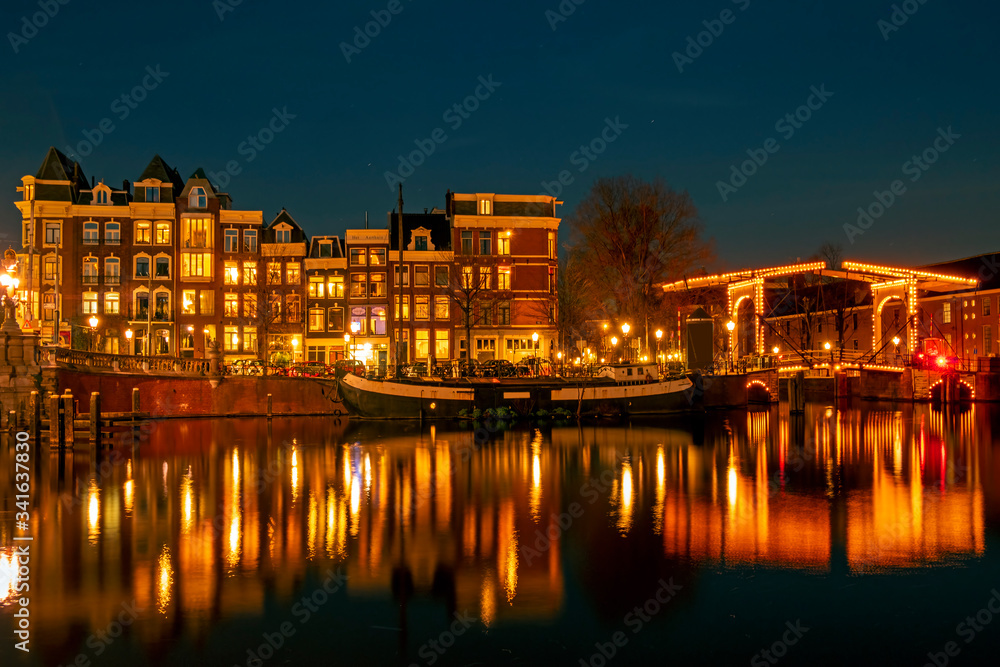 City scenic from Amsterdam at the river Amstel  in the Netherlands at night