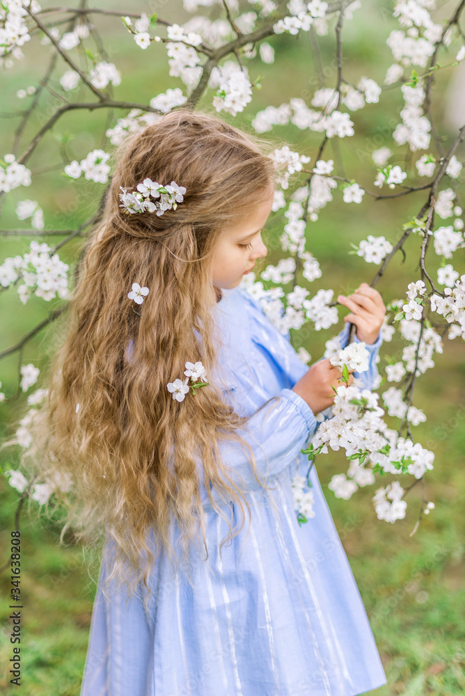 portrait of a child's girl in a blooming garden. Spring photo. Flowers in your hair portrait of a child's girl in a blooming garden. Spring photo. Flowers in your hair