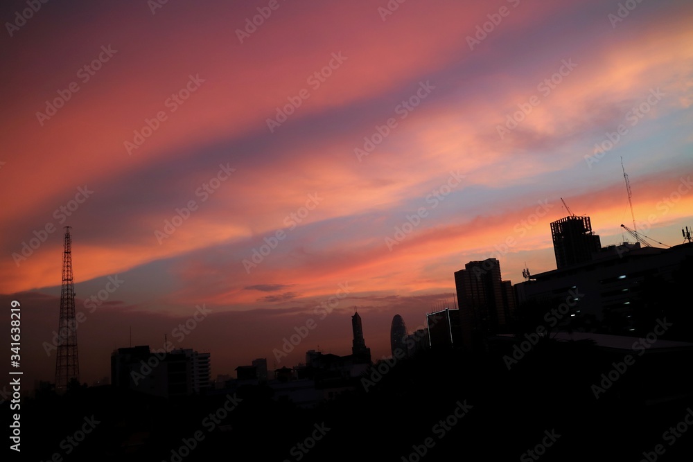 Night is Coming, Sunset Paradise with red and blue sky, cloud and building in big city. Business background concept with copy space, low key.