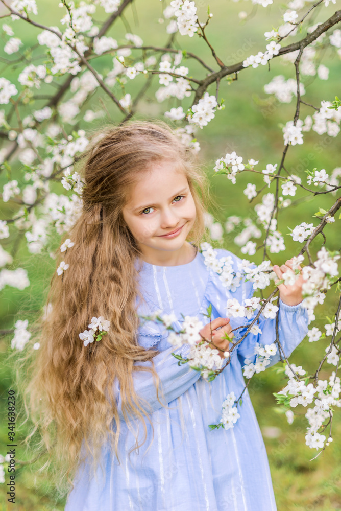 portrait of a child's girl in a blooming garden. Spring photo. Flowers in your hair portrait of a child's girl in a blooming garden. Spring photo. Flowers in your hair