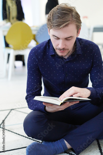 young muslim man reading Quran at home
