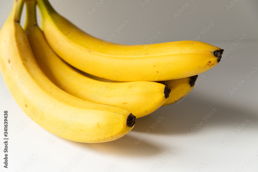 Bunch of ripe yellow bananas on a white background