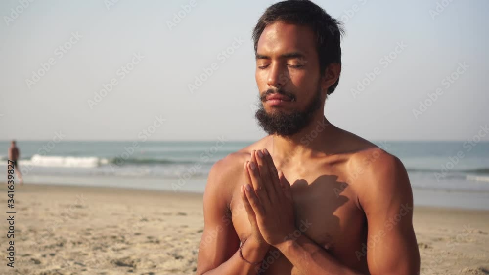 A man in the lotus position and practices yoga on the beach A man in the lotus position and practices yoga on the beach