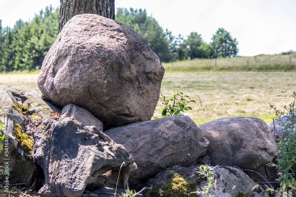 A pile of granite boulders collected at the edge of the field. Site about agriculture, nature, stone. Central Europe . A pile of granite boulders collected at the edge of the field. Site about agriculture, nature, stone. Central Europe .