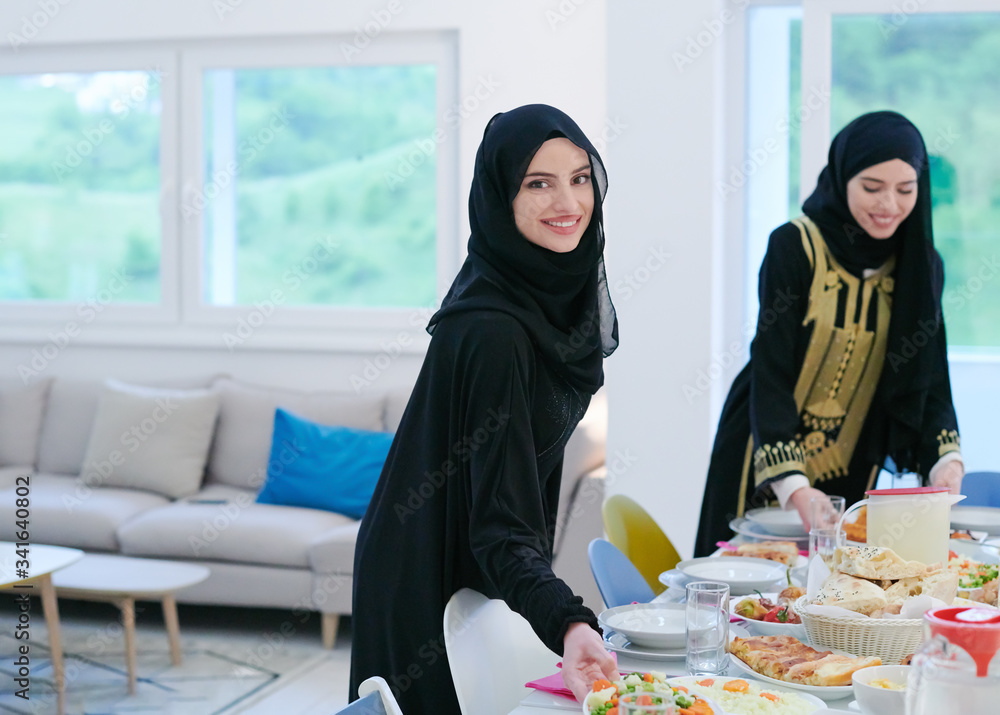 young muslim girls serving food on the table for iftar dinner young muslim girls serving food on the table for iftar dinner