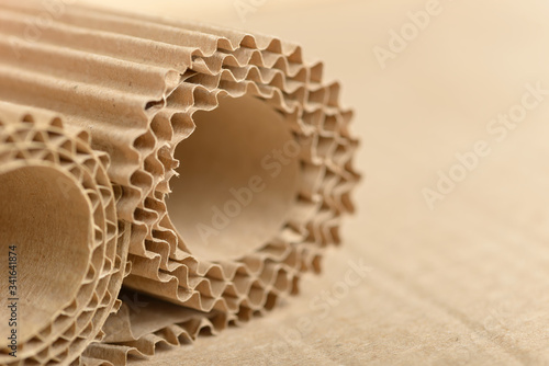 Carton or cardboard packing material. Texture of corrugated paper sheets made from cellulose. Supplies for creating boxes and packaging. Pasteboard background. Natural brown cardboard surface. photo