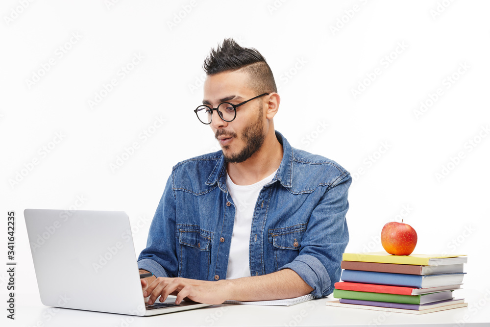 Happy looking student works on his portable computer. Happy looking student works on his portable computer.