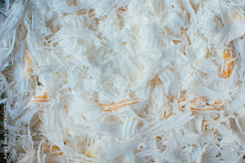 Fresh coconut flakes background. Detail of dried shaved coconut flakes. 