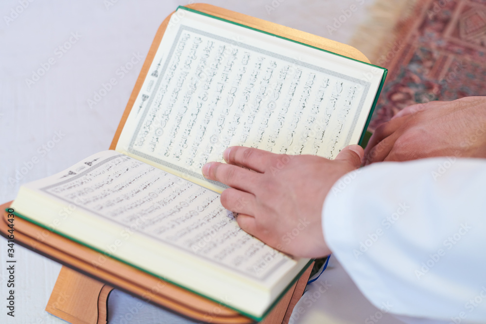Obraz premium arabian muslim man reading Quran at home