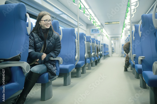 girl sits on a train / winter transport, one adult girl sits by the train window traveling