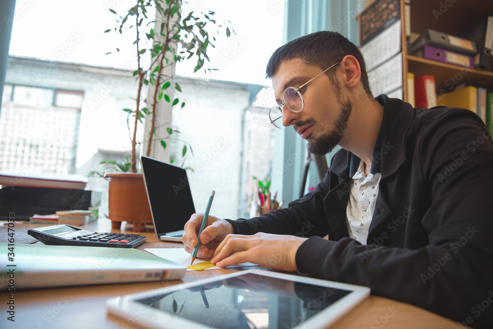 Writing, close up. Caucasian entrepreneur, businessman, manager working concentrated in office. Looks serios and busy, wearing classic attire. Concept of work, finance, business, success, leadership.