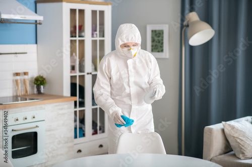 Woman in white workwear disinfecting the apartment © zinkevych