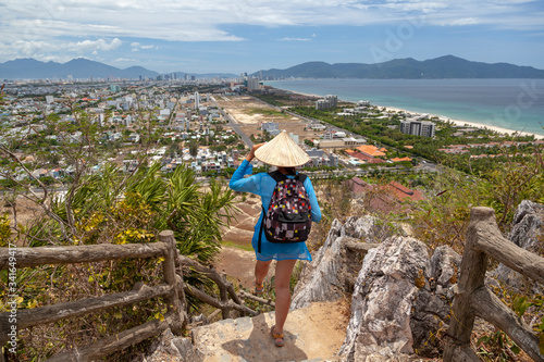 Travel and tourism, a backpacker girl stands on top of the Marble Mountains in Da Nang, Vietnam