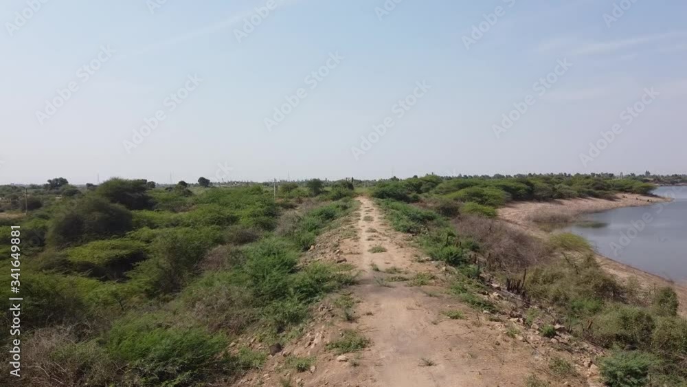 Drone shot of a walking path between lake shore and villages countryside Drone shot of a walking path between lake shore and villages countryside