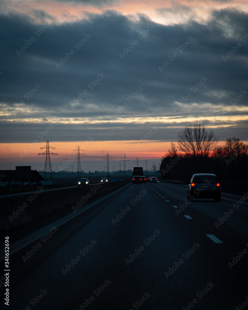 Traffic on the main highway through the landscape of Skåne (Scania) in southern Sweden during a winter sunset.