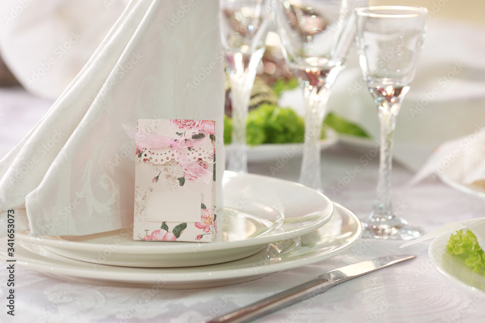 White table setting from above. Elegant empty plate, cutlery, napkin and glass on shabby chic or vintage planked wood table.