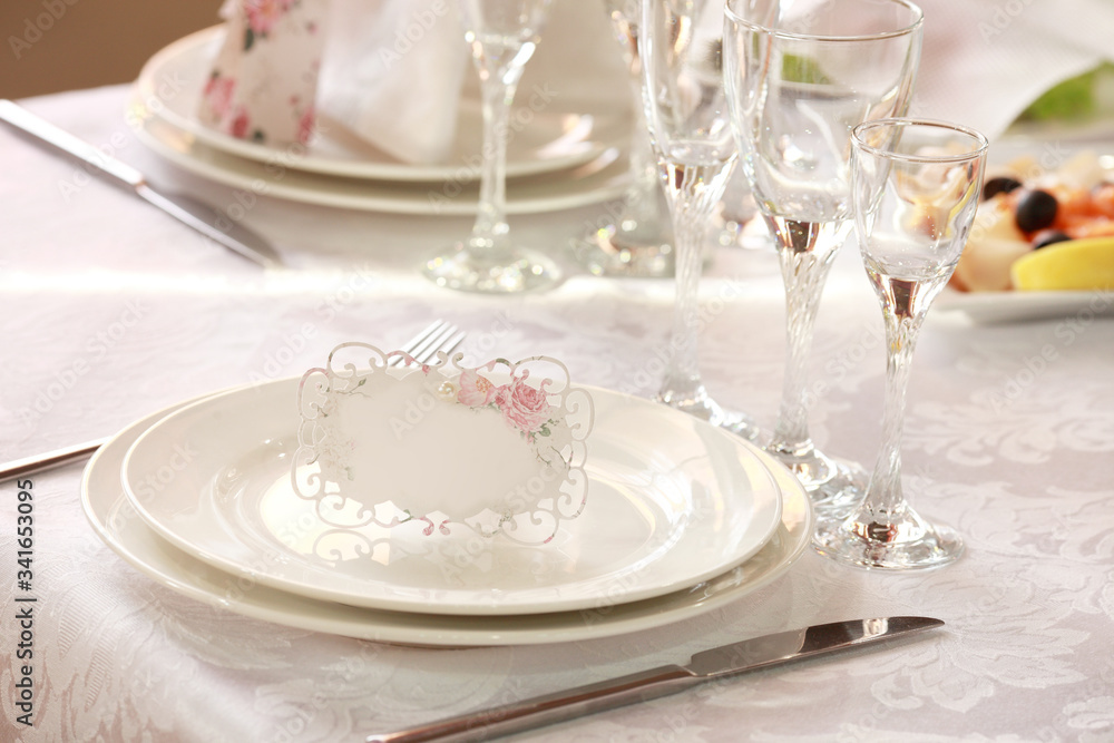 White table setting from above. Elegant empty plate, cutlery, napkin and glass on shabby chic or vintage planked wood table. White table setting from above. Elegant empty plate, cutlery, napkin and glass on shabby chic or vintage planked wood table.