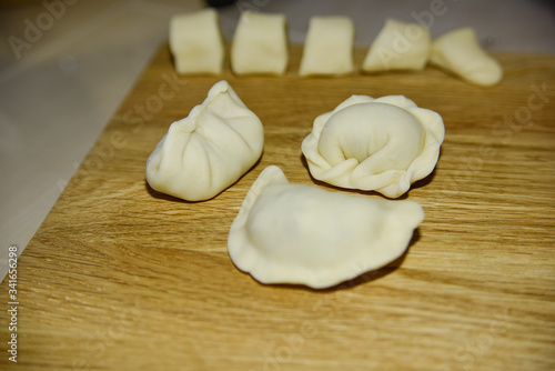 three dumplings of different shape on the wooden deck.