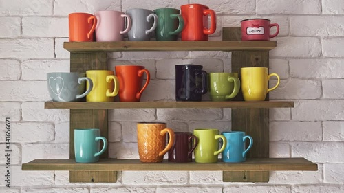 Time lapse shot set of moving multi colored coffee cups on a shelf on the white brick wall in cozy city cafe liten natural window light