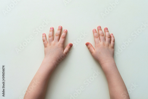 Small children's hands on a white table