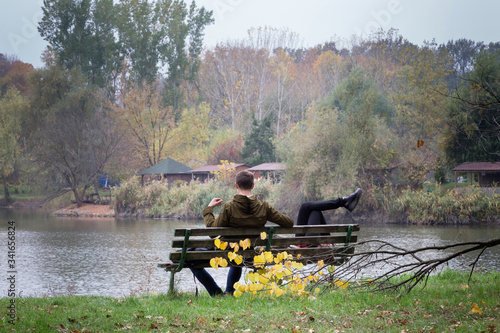 Romantic couple on a bench by the lake in autumn.